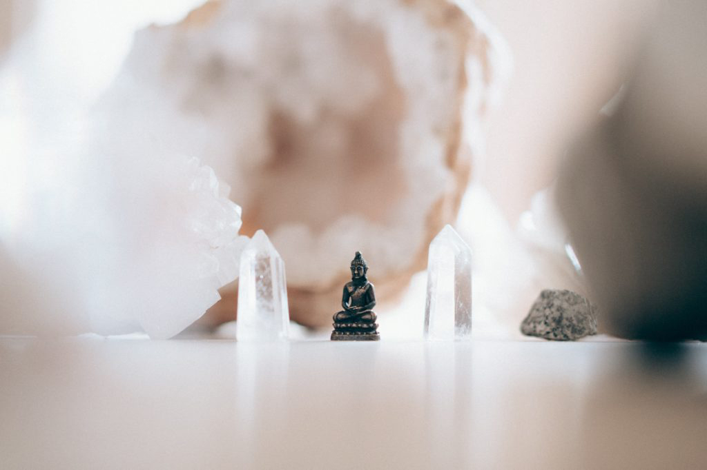 Buddha statue surrounded by crystals.